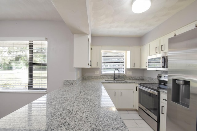 1668 Fort Smith Blvd, Deltona, FL 32725 - kitchen featuring stainless steel appliances, a sink, white cabinetry, and light stone countertops