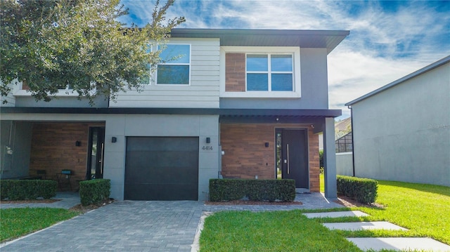 4414 Le Reve Ct, Kissimmee, FL 34746 - view of front facade with a garage, a front yard, decorative driveway, and stucco siding