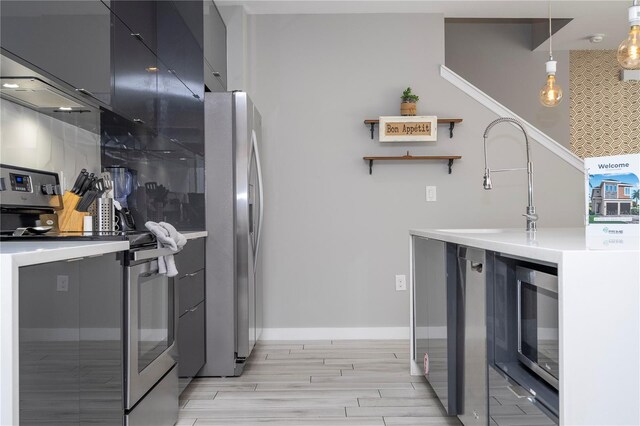 4414 Le Reve Ct, Kissimmee, FL 34746 - kitchen with stainless steel appliances, modern cabinets, wood tiled floors, pendant lighting, and baseboards