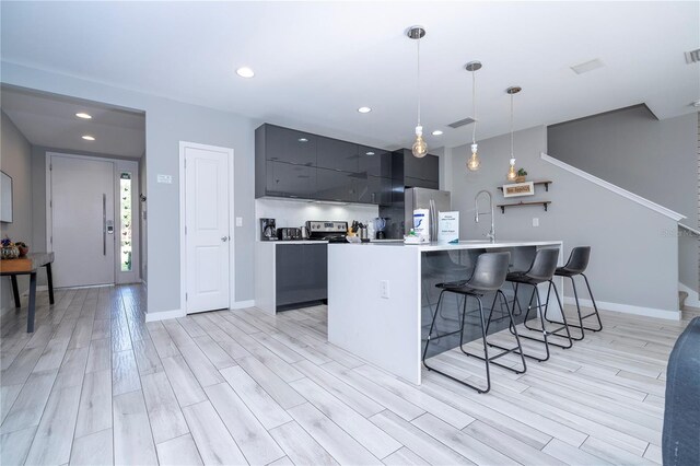 4414 Le Reve Ct, Kissimmee, FL 34746 - kitchen featuring stainless steel appliances, a kitchen breakfast bar, light countertops, modern cabinets, and light wood-type flooring