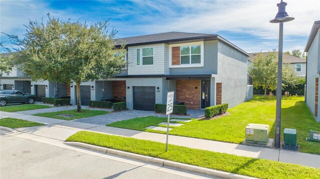 4414 Le Reve Ct, Kissimmee, FL 34746 - modern home with an attached garage, a front yard, driveway, and stucco siding