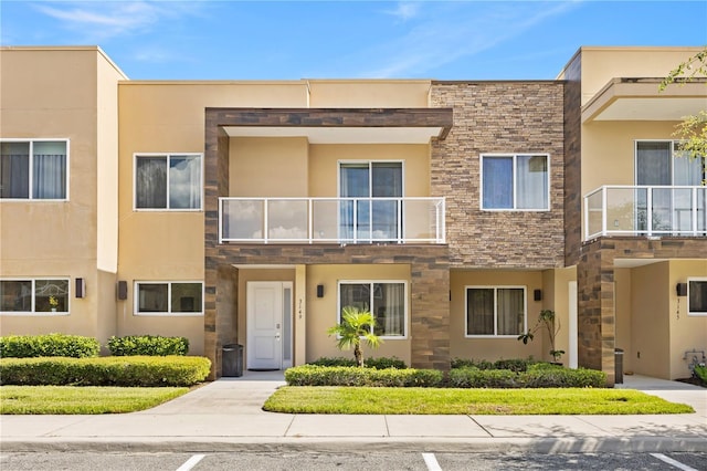 3149 Brasilia Ave, Kissimmee, FL 34747 - view of front facade with a balcony, stone siding, and stucco siding