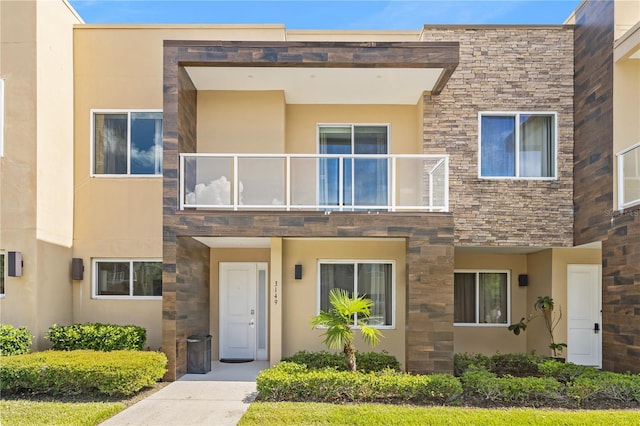 3149 Brasilia Ave, Kissimmee, FL 34747 - view of front facade with a balcony, stone siding, and stucco siding