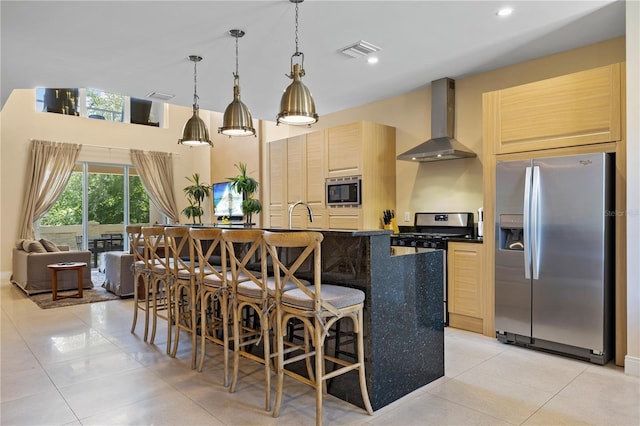 3149 Brasilia Ave, Kissimmee, FL 34747 - kitchen with stainless steel appliances, wall chimney exhaust hood, light tile patterned floors, dark countertops, and a kitchen bar