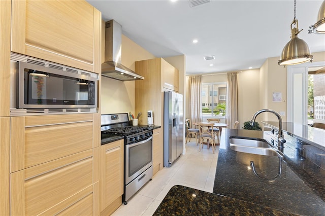 3149 Brasilia Ave, Kissimmee, FL 34747 - kitchen with stainless steel appliances, wall chimney range hood, light tile patterned floors, decorative light fixtures, and dark stone counters