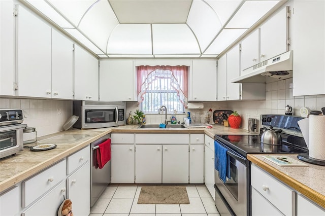 251 Tropic Blvd W, Largo, FL 33770 - kitchen with stainless steel appliances, a sink, under cabinet range hood, light countertops, and tasteful backsplash