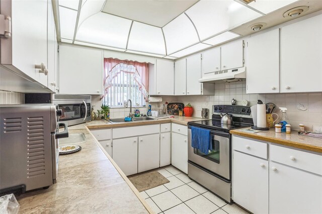 251 Tropic Blvd W, Largo, FL 33770 - kitchen featuring stainless steel appliances, under cabinet range hood, a sink, and light countertops