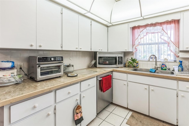 251 Tropic Blvd W, Largo, FL 33770 - kitchen with a sink, stainless steel appliances, decorative backsplash, and white cabinetry