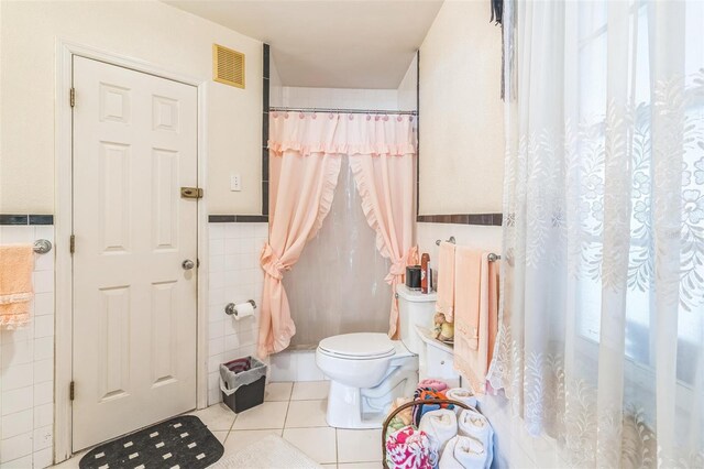 251 Tropic Blvd W, Largo, FL 33770 - full bathroom featuring tile walls, toilet, tile patterned flooring, a wainscoted wall, and curtained shower