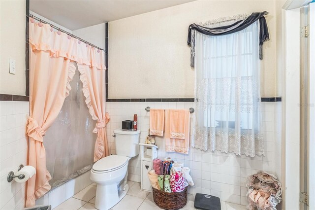 251 Tropic Blvd W, Largo, FL 33770 - bathroom with tile walls, toilet, tile patterned flooring, curtained shower, and wainscoting