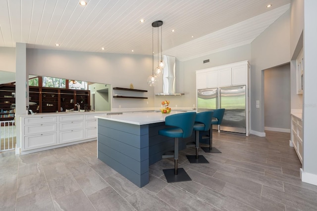20 Twelve Oaks Trl, Ormond Beach, FL 32174 - kitchen with stainless steel built in refrigerator, wall chimney range hood, wood ceiling, a kitchen island, and white cabinetry