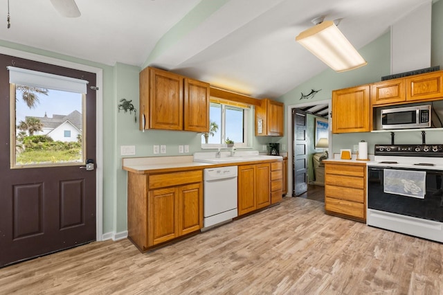 4039 S Atlantic Ave, Port Orange, FL 32127 - kitchen featuring white appliances, lofted ceiling, light countertops, light wood-type flooring, and brown cabinetry