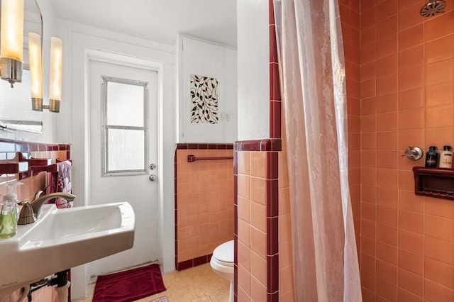 4039 S Atlantic Ave, Port Orange, FL 32127 - bathroom with tiled shower, tile walls, and wainscoting