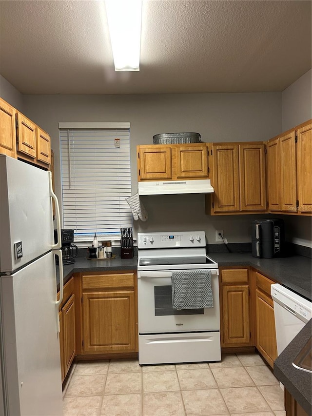 3417 Westchester Square Blvd Unit 202, Orlando, FL 32835 - kitchen with white appliances, under cabinet range hood, dark countertops, brown cabinetry, and light tile patterned floors