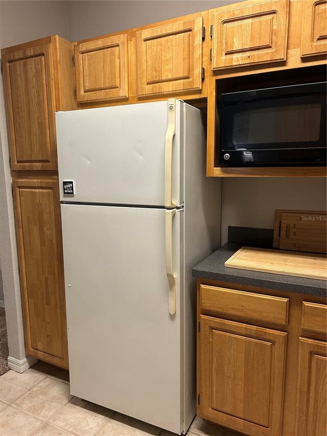 3417 Westchester Square Blvd Unit 202, Orlando, FL 32835 - kitchen featuring freestanding refrigerator, black microwave, dark countertops, and brown cabinets