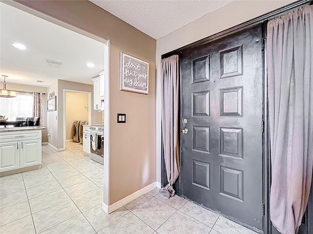 1803 Meadow Pond Way, Orlando, FL 32824 - entryway featuring light tile patterned floors, baseboards, and a textured ceiling