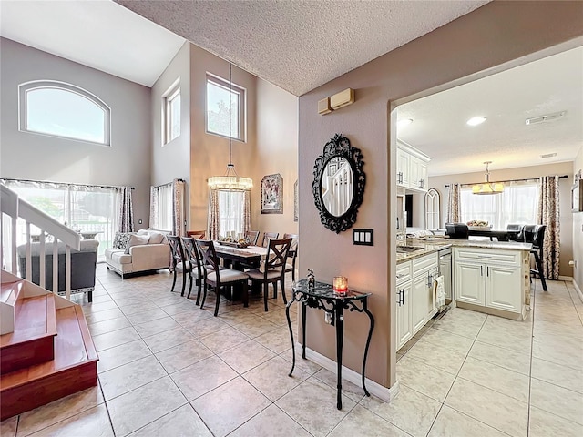 1803 Meadow Pond Way, Orlando, FL 32824 - dining space with a chandelier, light tile patterned floors, baseboards, and a textured ceiling