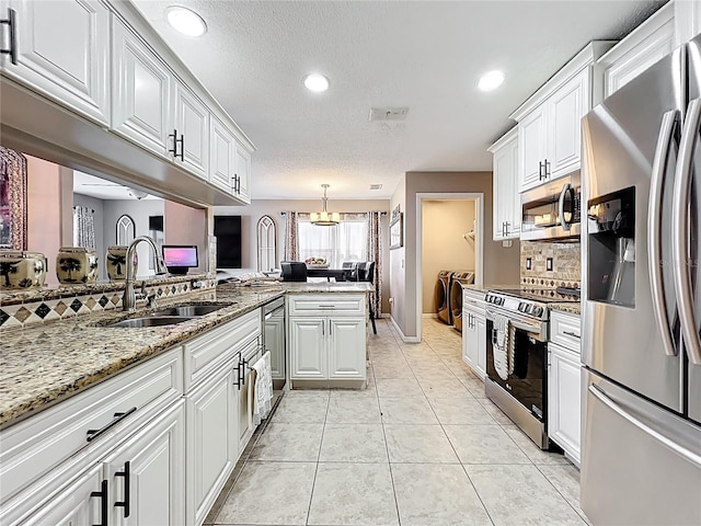 1803 Meadow Pond Way, Orlando, FL 32824 - kitchen featuring appliances with stainless steel finishes, a sink, decorative backsplash, white cabinetry, and light stone counters