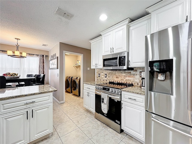 1803 Meadow Pond Way, Orlando, FL 32824 - kitchen featuring appliances with stainless steel finishes, independent washer and dryer, tasteful backsplash, white cabinets, and a textured ceiling