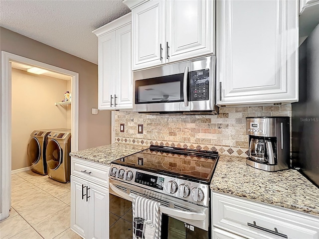 1803 Meadow Pond Way, Orlando, FL 32824 - kitchen featuring appliances with stainless steel finishes, washer and clothes dryer, backsplash, white cabinets, and a textured ceiling