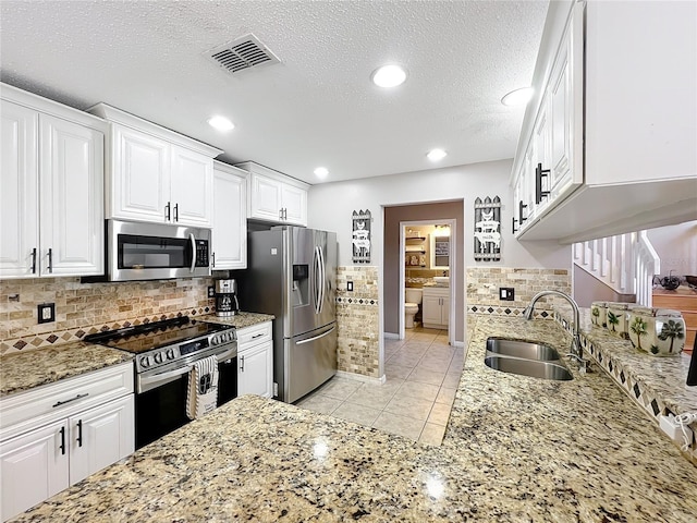 1803 Meadow Pond Way, Orlando, FL 32824 - kitchen featuring stainless steel appliances, a sink, white cabinets, light stone counters, and light tile patterned floors