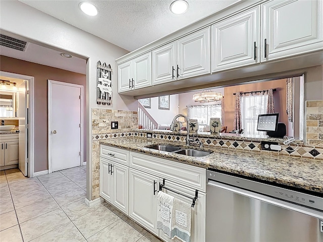 1803 Meadow Pond Way, Orlando, FL 32824 - kitchen with stainless steel dishwasher, a sink, decorative backsplash, light stone counters, and white cabinets