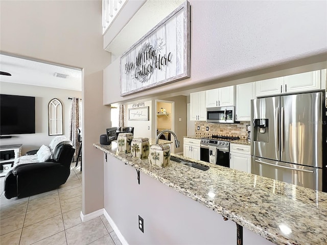 1803 Meadow Pond Way, Orlando, FL 32824 - kitchen with appliances with stainless steel finishes, a sink, light stone countertops, light tile patterned flooring, and a high ceiling