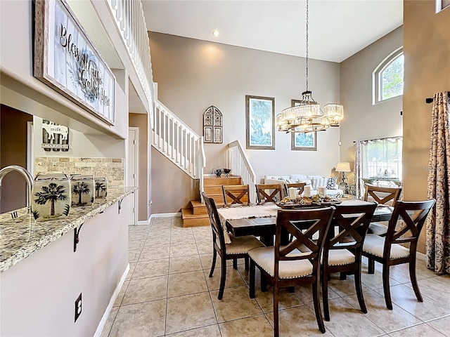 1803 Meadow Pond Way, Orlando, FL 32824 - dining room with a high ceiling, baseboards, a chandelier, stairway, and light tile patterned floors