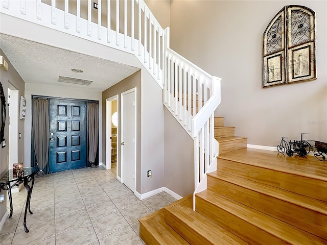 1803 Meadow Pond Way, Orlando, FL 32824 - tiled foyer entrance featuring baseboards, stairway, and a textured ceiling
