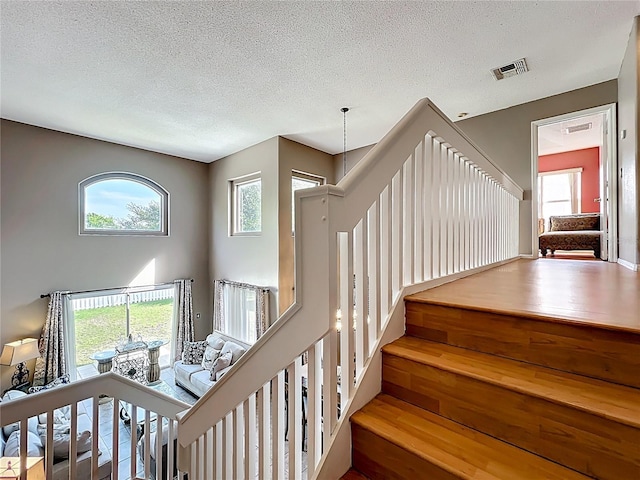 1803 Meadow Pond Way, Orlando, FL 32824 - staircase featuring a textured ceiling and healthy amount of natural light