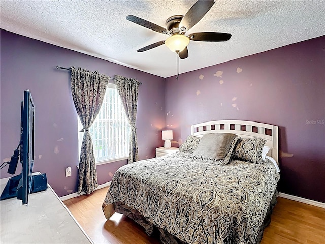 1803 Meadow Pond Way, Orlando, FL 32824 - bedroom featuring wood finished floors, a textured ceiling, baseboards, and a ceiling fan