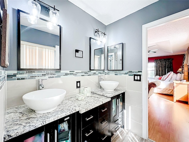 1803 Meadow Pond Way, Orlando, FL 32824 - full bath with tile walls, ensuite bath, double vanity, a ceiling fan, and wood finished floors
