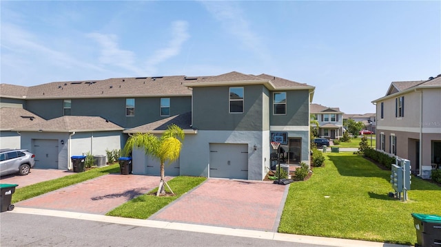 13452 Sagestone Dr, Winter Garden, FL 34787 - view of front of property with driveway, stucco siding, a residential view, a front yard, and central AC unit