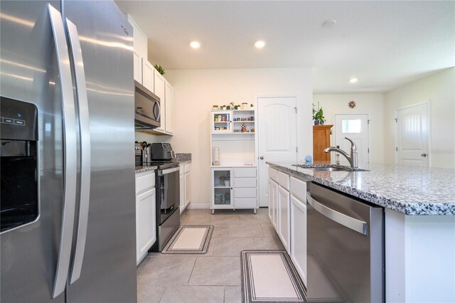 13452 Sagestone Dr, Winter Garden, FL 34787 - kitchen featuring appliances with stainless steel finishes, a sink, white cabinets, light stone counters, and recessed lighting