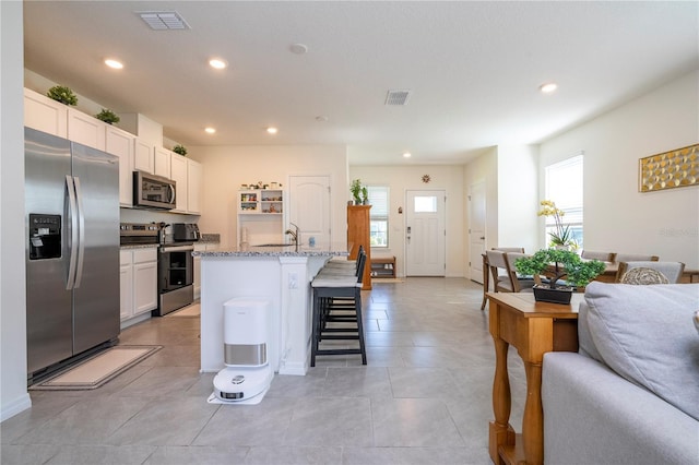 13452 Sagestone Dr, Winter Garden, FL 34787 - kitchen with stainless steel appliances, a breakfast bar, recessed lighting, an island with sink, and open floor plan