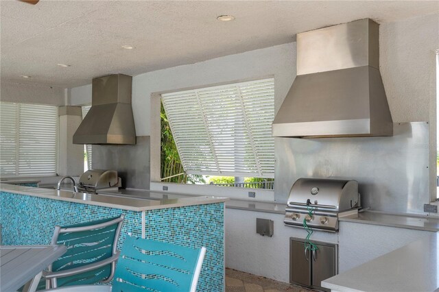 13452 Sagestone Dr, Winter Garden, FL 34787 - kitchen featuring wall chimney exhaust hood, recessed lighting, a textured ceiling, and light countertops