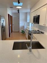 1422 Spalding Rd, Winter Springs, FL 32708 - kitchen featuring black microwave, stainless steel fridge, and light countertops