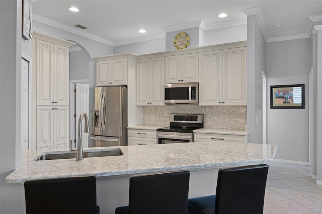 1124 Hidden Blf, Clermont, FL 34711 - kitchen with stainless steel appliances, a sink, backsplash, arched walkways, and light stone counters