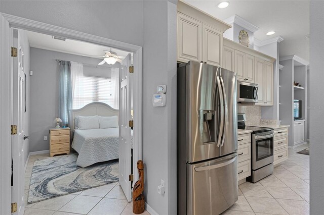 1124 Hidden Blf, Clermont, FL 34711 - kitchen featuring appliances with stainless steel finishes, light tile patterned floors, light countertops, cream cabinets, and baseboards