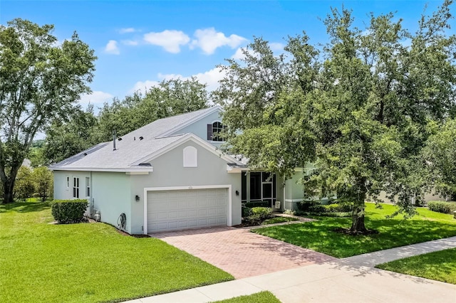 1124 Hidden Blf, Clermont, FL 34711 - view of front of home featuring decorative driveway, stucco siding, a garage, and a front lawn