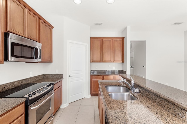 7715 Anselmo Ln, Windermere, FL 34786 - kitchen with stainless steel appliances, a sink, dark stone counters, and light tile patterned floors