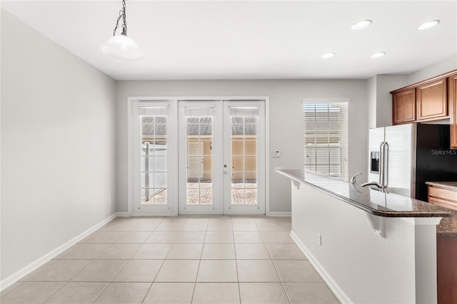 7715 Anselmo Ln, Windermere, FL 34786 - kitchen with stainless steel fridge, baseboards, recessed lighting, french doors, and light tile patterned floors