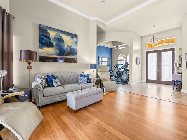 1319 Johns Cove Ln, Oakland, FL 34787 - living area with arched walkways, wood finished floors, ornamental molding, french doors, and a ceiling fan