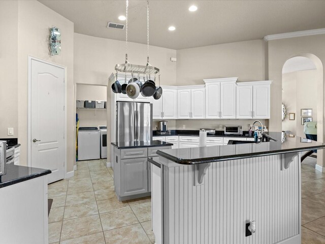 1319 Johns Cove Ln, Oakland, FL 34787 - kitchen with freestanding refrigerator, washing machine and dryer, dark countertops, a kitchen bar, and recessed lighting