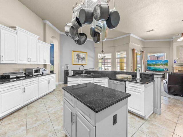 1319 Johns Cove Ln, Oakland, FL 34787 - kitchen featuring a sink, a kitchen island, dishwasher, open floor plan, and arched walkways