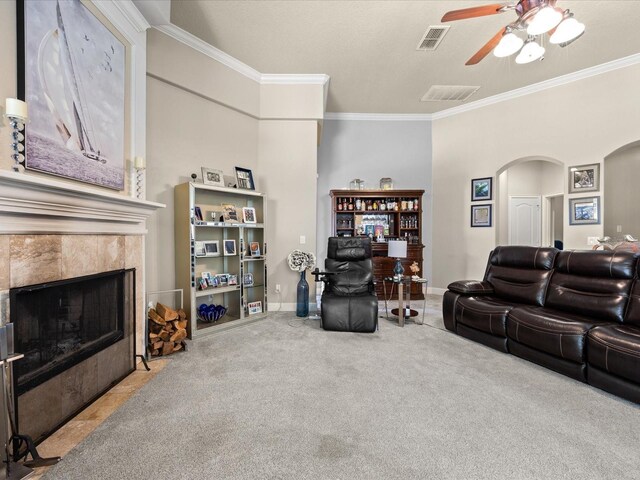 1319 Johns Cove Ln, Oakland, FL 34787 - carpeted living area featuring ornamental molding, ceiling fan, arched walkways, a tile fireplace, and baseboards