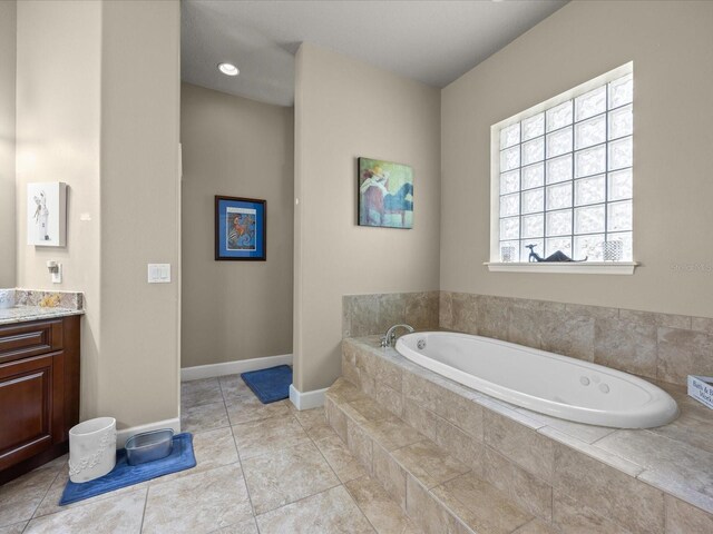 1319 Johns Cove Ln, Oakland, FL 34787 - bathroom featuring vanity, a garden tub, baseboards, and tile patterned flooring