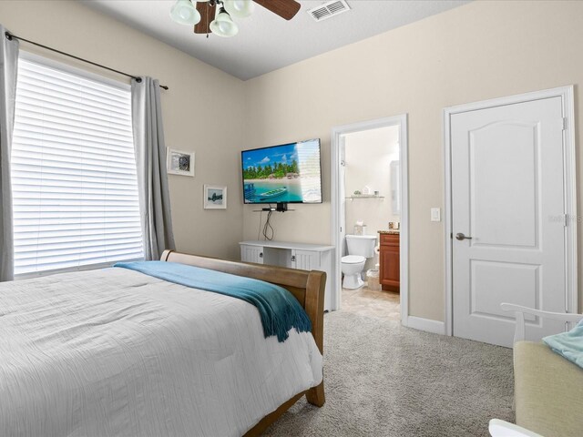 1319 Johns Cove Ln, Oakland, FL 34787 - bedroom with light colored carpet, ensuite bathroom, baseboards, and ceiling fan
