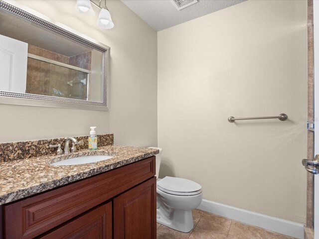 1319 Johns Cove Ln, Oakland, FL 34787 - bathroom featuring vanity, a tile shower, toilet, baseboards, and tile patterned floors