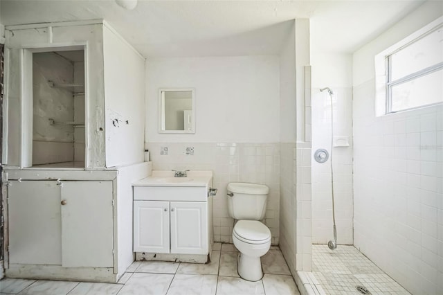 1601 Randolph St, Deltona, FL 32725 - bathroom with vanity, a shower stall, toilet, a wainscoted wall, and tile walls